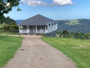 una casa en una colina con un camino de tierra en Cloud Hill, en Maleny