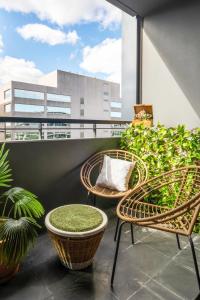 a balcony with wicker chairs and tables on a building at Escape To Melbourne - Stylish 1 Bedroom-Gym - Aircon -Balcony in Melbourne