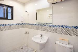 bagno con lavandino, servizi igienici e specchio di 淡水民宿-台北Yes Hotel a Tamsui