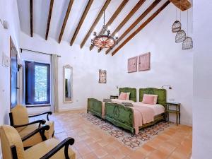 a bedroom with a green bed and a chair at Casa Rodriguillo in Pinoso