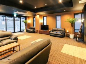 a large living room with couches and a flat screen tv at HOTEL LiVEMAX Minamihashimoto Ekimae in Sagamihara