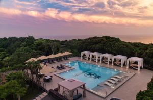 una vista aérea de una piscina con mesas y sombrillas en Kensington Resort Jeju Jungmun en Seogwipo