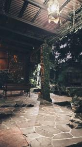 a stone patio with a bench under a pavilion at Riverside cabin in Pengalongan