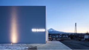 eine blaue Tür zu einem Gebäude mit einem Berg im Hintergrund in der Unterkunft THE GARDEN in Fujikawaguchiko