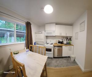 cocina con mesa y comedor en Beautiful Maple ridge farm cabin unit A, en Distrito municipal de Maple Ridge