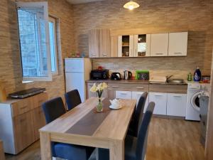 a kitchen with a wooden table with chairs and a kitchen with white appliances at Holiday house in Kotor