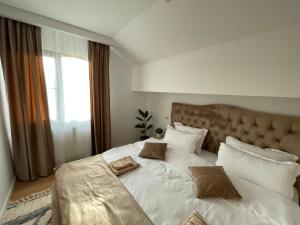 a bedroom with a large white bed with pillows at Casa cu Pitici in Vama