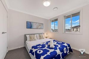 1 dormitorio con 1 cama y 2 ventanas en KozyGuru / Austral / 5Bed House / NAU015, en Horningsea Park