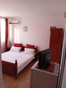 a bedroom with two beds and a tv in it at casa andrei m in Eforie Sud