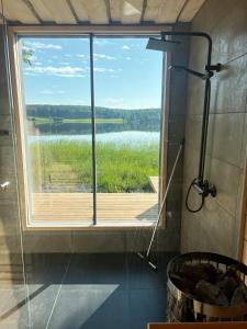 a large window in a bathroom with a view of a lake at Lake Cottage with sauna (near City) in Jyväskylä