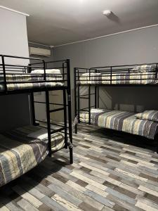 three bunk beds in a room with a floor at Sunraysia Stays in Mildura