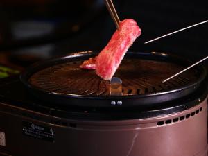 a piece of meat cooking on top of a toaster oven at 雲海の宿　月星亭 in Takeda