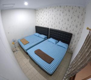 Un pequeño dormitorio con una cama azul en una habitación en Kenayan Homestay Jogja, en Salakan