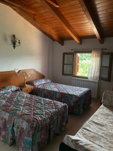 una camera d'albergo con tre letti e una finestra di Casa Enriu-Alojamiento y desayuno a Vilaller