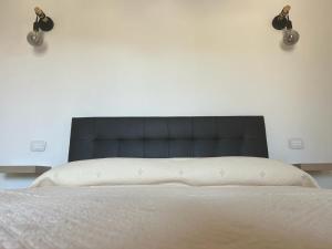 a bed with a black headboard in a bedroom at Agriturismo Il Giardino Degli Olivi Appartamenti in Castiglione della Pescaia