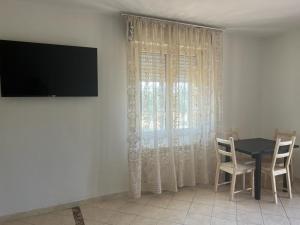 Un comedor con una mesa y una ventana. en Agriturismo Il Giardino Degli Olivi Appartamenti, en Castiglione della Pescaia