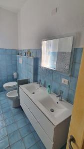 een badkamer met een witte wastafel en een toilet bij palau casa vacanza le ginestre in Palau