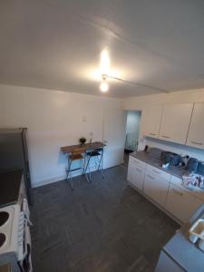an empty kitchen with a table and chairs in it at Derby City Apartment with free parking in Derby