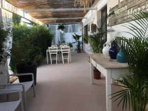 een patio met een tafel, stoelen en planten bij Mazzara Farm in Manduria