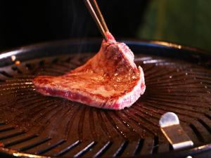 a piece of meat cooking on a grill at 雲海の宿　月星亭 in Takeda