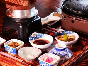 a table with bowls of food next to a coffee maker at 雲海の宿　月星亭 in Takeda