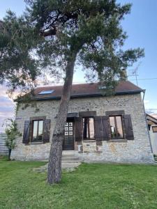 una casa de piedra con un árbol delante en Maisonnette à la campagne 