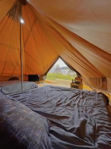 a tent with a bed in it with a window at The Backyard Glamping Cameron Highlands in Tanah Rata
