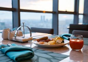 - une table avec une assiette de nourriture et une boisson dans l'établissement Shenyang Marriott Hotel, à Shenyang