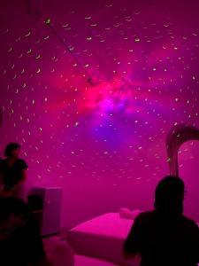 a purple room with a bed with a pink ceiling at 墾丁圓石灘 Kenting Pebble Beach in Fangshan