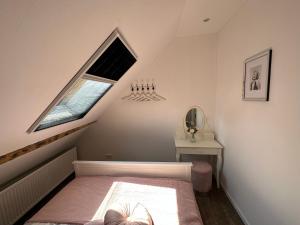 a small attic bedroom with a bed and a window at Dachgeschosswohnung im Huus an`t Koornfeld in Osteel