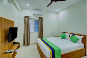 um quarto com uma cama e uma televisão de ecrã plano em Treebo Trend Fortune Stay Inn em Bangalore