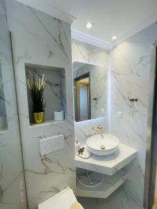 a white bathroom with a sink and a mirror at Allea Hotel and Apartments in Toroni