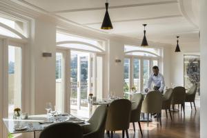a man sitting at a table in a restaurant at Four Seasons Hotel The Westcliff in Johannesburg