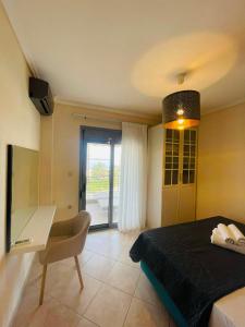 a bedroom with a bed and a table and a chair at Allea Hotel and Apartments in Toroni