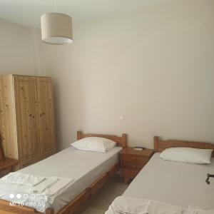 two twin beds in a room with two cabinets at 'Αγριοι Λιμένες in Iria