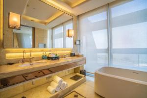 a bathroom with a tub and a sink and a mirror at Sheraton Huzhou Taihu Lake Hot Spring Resort & Spa in Huzhou