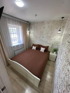 a bedroom with a large bed and a window at Sport Hotel Terra in Ustʼ-Kamenogorsk
