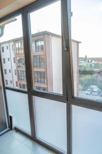 a room with four windows with a view of a building at Apusului Residence Modern 2 Bedroom Apartment in Roşu