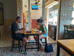 Un uomo e una donna seduti a un tavolo di Harmony Guest House a Padangbai