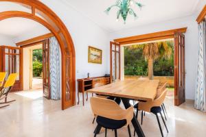 uma sala de jantar com uma mesa de madeira e cadeiras em Villa Sa Coma em Sa Coma