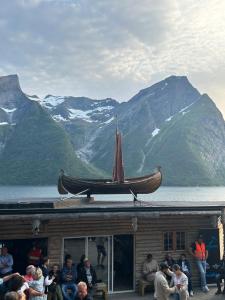 a group of people sitting on a building with a boat on top at Line på Hauane1 in Volda
