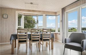 a dining room with a table and chairs and windows at Amazing Home In Snedsted With 4 Bedrooms, Sauna And Wifi in Skyum