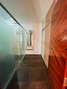 um corredor com uma porta de madeira e uma parede de vidro em Shyam Sudha Home Stay em Ujaim