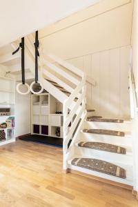een witte trap in een kamer met houten vloeren bij Oslo: Quiet and cosy home with garden and free parking in Grorud