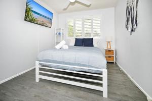 a white bedroom with a bed and a window at Spacious 3 Bedroom Delight - Shops & Beaches ZG1 in Caloundra +24 photos