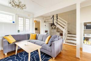 een woonkamer met een bank en een trap bij Oslo: Quiet and cosy home with garden and free parking in Grorud