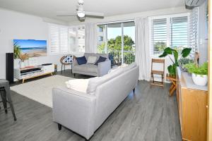 a living room with a couch and a table at Spacious 3 Bedroom Delight - Shops & Beaches ZG1 in Caloundra