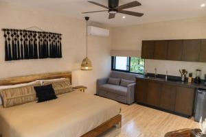 a bedroom with a bed and a couch and a ceiling fan at New Suite Deluxe Tulum Ophelia Community Living in Tulum