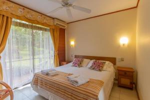 a bedroom with a bed and a window with towels on it at Hostal Uruhao in Hanga Roa