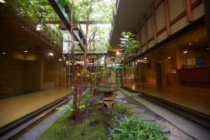 a building with a bench in the middle of a garden at Wakamatsu Hot Spring Resort in Hakodate